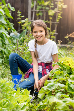 Beautiful smiling teenage girl working at garden