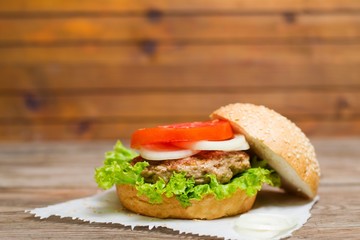 Juicy homemade hamburger with fresh vegetables in table. selective focus 
