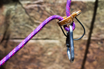 Climbing: belay device with violet rope and aluminum carabiner