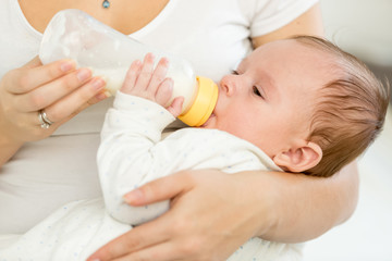 Fototapeta na wymiar Portrait of 3 months old baby eating milk from bottle