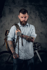 Portrait of bearded hipster male with bag and bicycle.