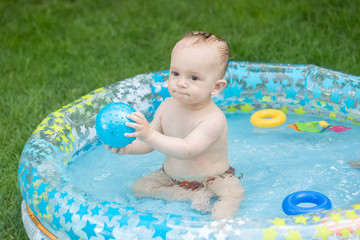 Cute baby playing with boy in the swimming at backyard