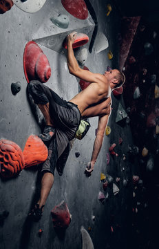 Man climbing on an indoor climbing wall.