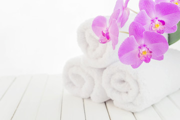 Fototapeta na wymiar White bath towels and orchid flower