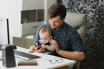 Young father working from home and taking care of his baby