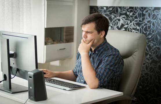 Portrait of concentrated man working at computer