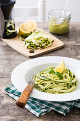 Zucchini noodles with pesto sauce on wooden table

