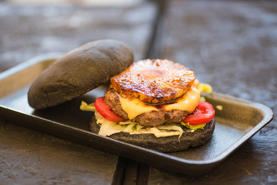 Black burger with pineapple