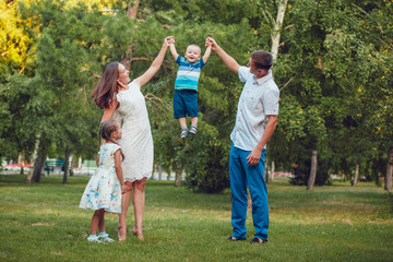 Naklejka na ściany i meble Young family of four having fun in the park