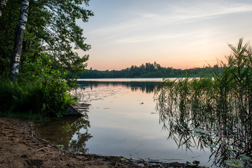 Beautiful summer sunset at the lake with blue sky, red and orang