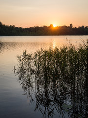 Beautiful summer sunset at the lake with blue sky, red and orang