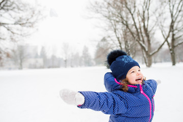 Fototapeta na wymiar Cute little girl playing outside in winter nature