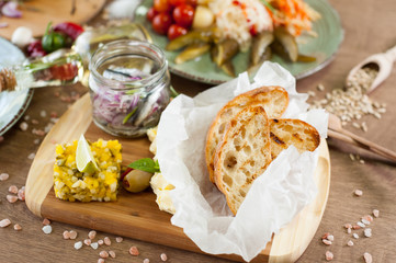 Salted fish, vegetables, bread, olive oil and other spices, condiments, meals and snacks on the wooden background