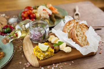 Salted fish, vegetables, bread, olive oil and other spices, condiments, meals and snacks on the wooden background