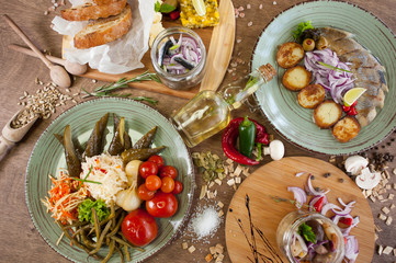 Salted fish, vegetables, bread, olive oil and other spices, condiments, meals and snacks on the wooden background