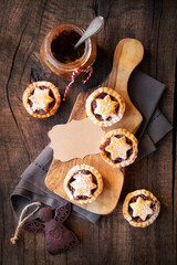 Traditional festive Christmas mince pies with a jar of homemade mincemeat and an empty tag. Overhead view