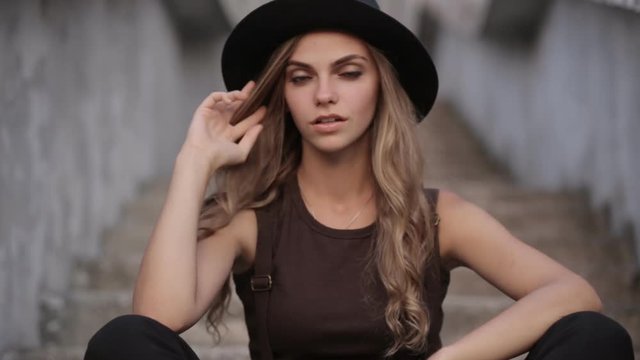 charming girl in a black hat poses for the camera