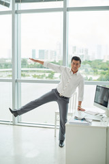 Vietnamese entrepreneur doing balance exercise in office