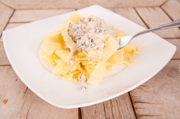 Pappardelle with chanterelle and creame being eaten with a fork