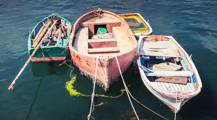 Fototapeta na wymiar Old small wooden fishing boats moored in port
