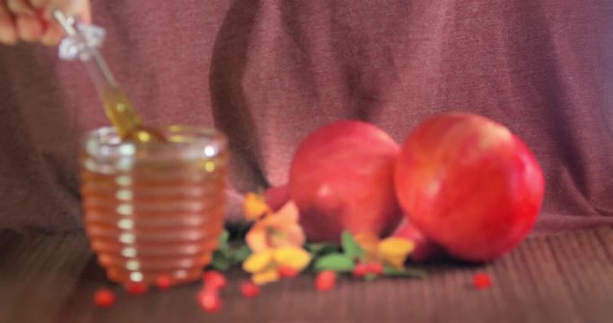 Honey poured on the pomegranate and apples. Jewishs new year Rosh Ha Shana.4K.
