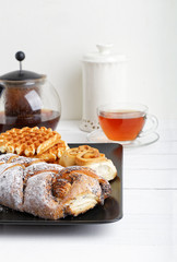 Pastry and cup of tea on white wooden table