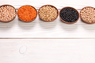 Bowls of various legumes on wooden background,healthy food,vegan food.