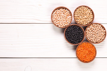 Bowls of various legumes on wooden background,healthy food,vegan food.