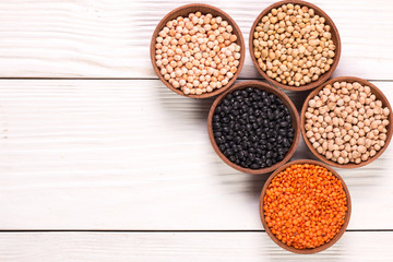 Bowls of various legumes on wooden background,healthy food,vegan food.