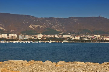 Sea resort town of Gelendzhik in sunny day on Black sea coast. View on city center with mountains in background. Letters on mountain from russian: Gelendzhik