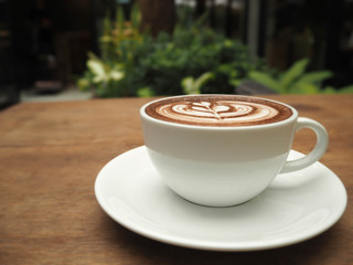coffee hot with art creamy milk on a wooden table