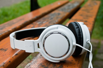 Casque audio blanc posés sur un banc en extérieur
