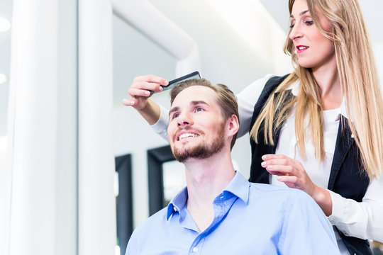 Haircutter cutting hair of customer