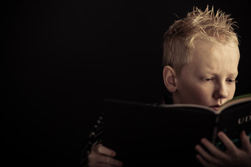 Serious boy reading book