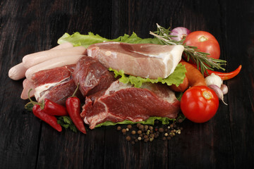 meat with spices and vegetables on wooden background