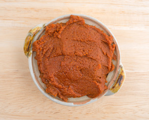 Red curry paste in a small bowl on a table top view.