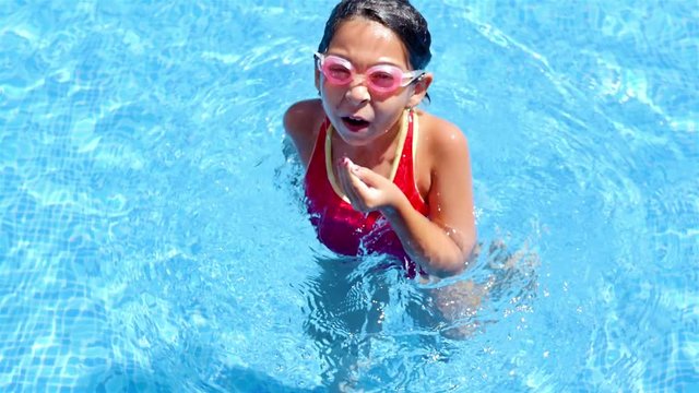 Cute little girl dunking head in a pool