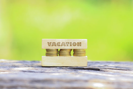 Business Concept - VACATION WORD, Golden coin stacked with wooden bar