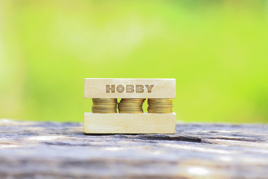 Business Concept - HOBBY WORD, Golden coin stacked with wooden bar