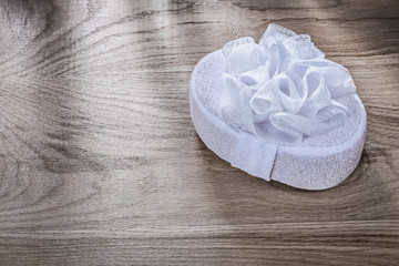 White bath sponge on wooden board bathing items concept