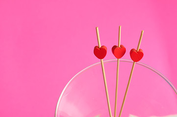 Valentine's Day. Three red hearts on sticks in a martini glass