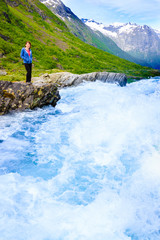 Tourist woman by Videfossen Waterfall in Norway
