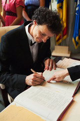 Groom signing wedding papers