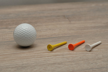 A golf ball with tee's isolated on a wooden background