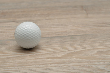 A golf ball isolated on wooden background