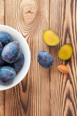 Vertical photo. Plums, sliced fruit, yellow flesh and kernel. Top view