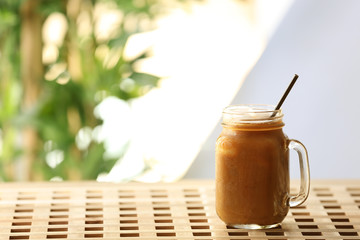 Iced coffee in glass jar on wooden table