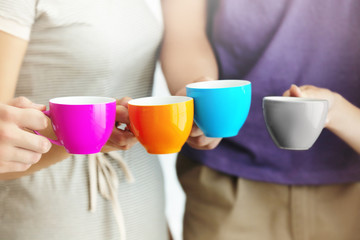 Group of people holding cups of coffee together