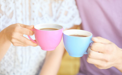 Couple  holding cups of coffee together