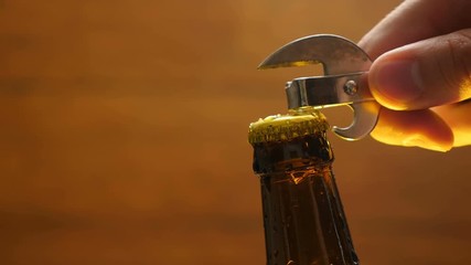 Opening cold bottle of beer with steam and spray (close-up)